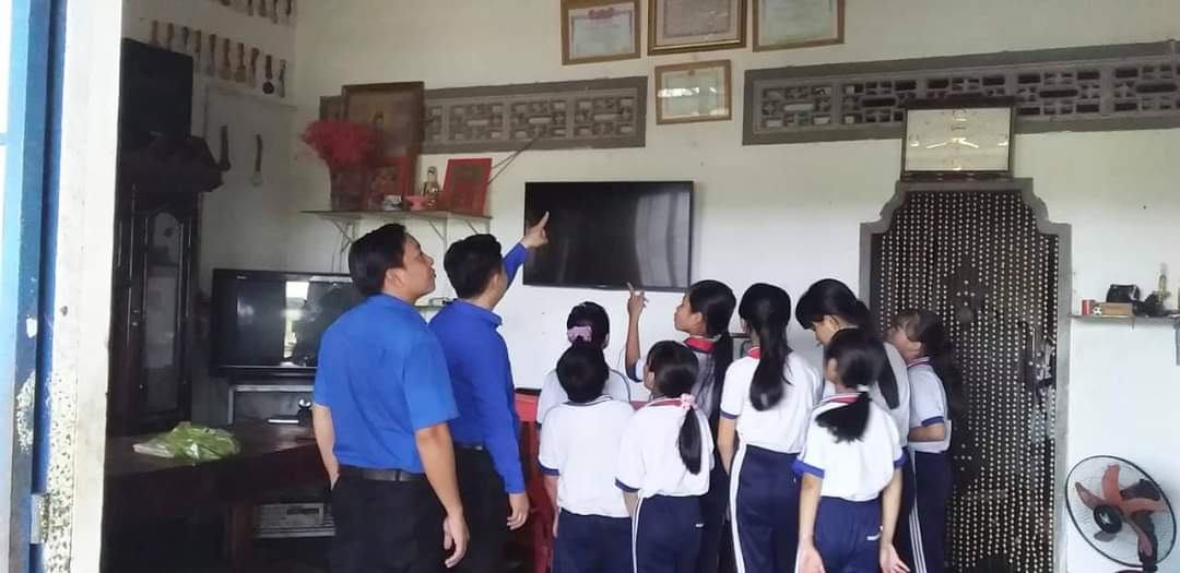 Hình 3 Đồng chí Phúc Phó BT xã đoàn và đồng chí Vũ đại diện Chi đoàn trường cùng các em học sinh tham quan nhà Bác Trương Thị Sinh